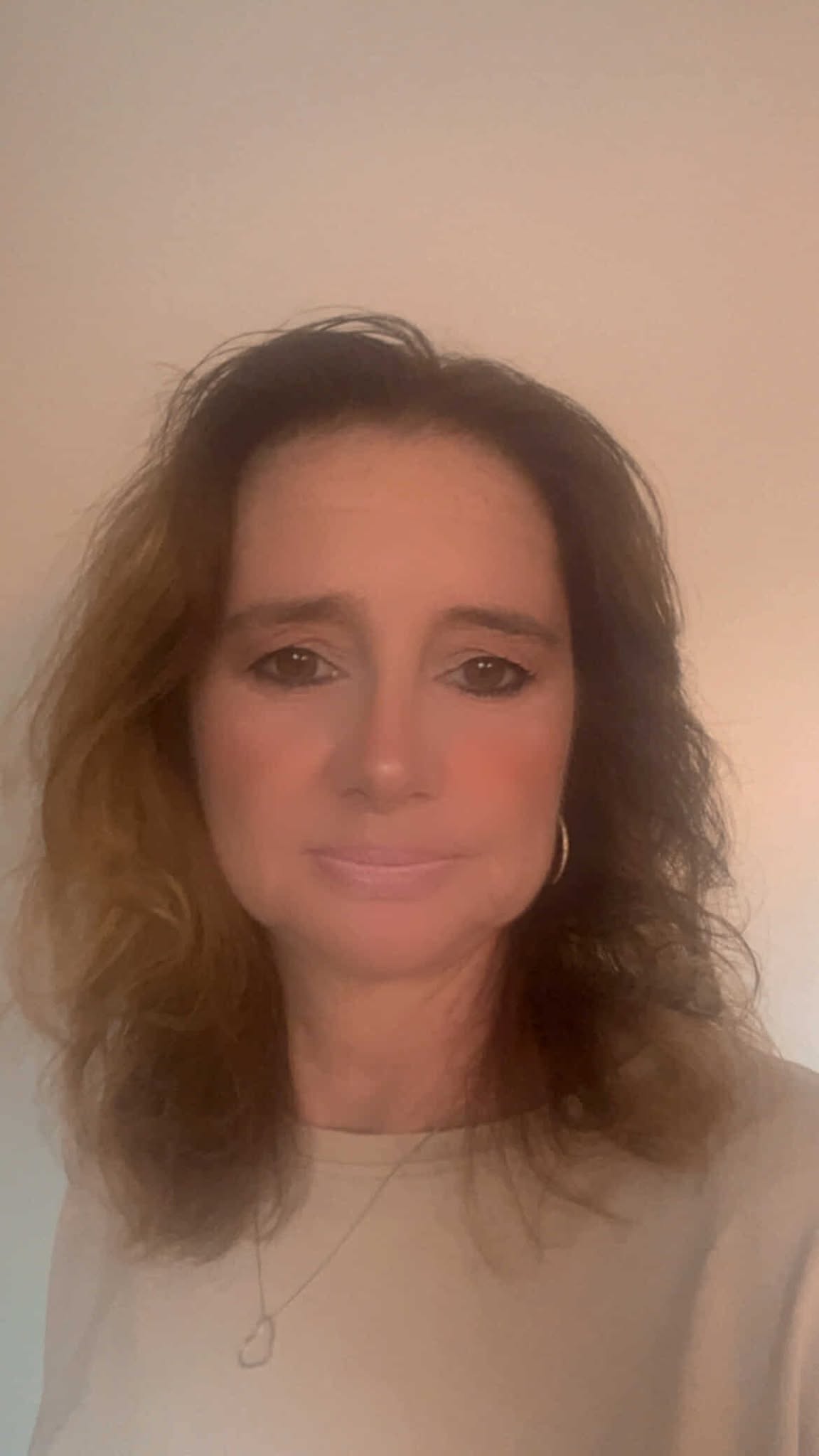 freundliche Frau, mittleren Alters, in sportlicher Kleidung, vor einem modernen Hintergrund